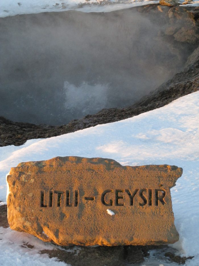 Steam rising from Litli Geysir (baby geyser). A rock carved with the words "Litli-Geysir" is in front of the steam in snow. Photo credit: M. Ciavardini. 