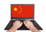 Image of Chinese flag on laptop computer screen; hands typing.