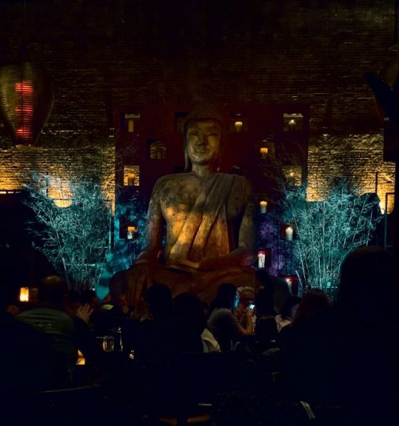 A tall Buddha in the low-lit dining room of Tao Uptown restaurant in New York City. Photo credit: L. Tripoli.